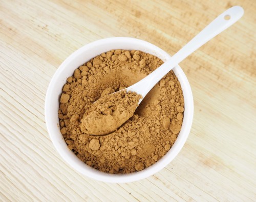 Guarana, Paulilinia cupana, powder in a bowl with spoon